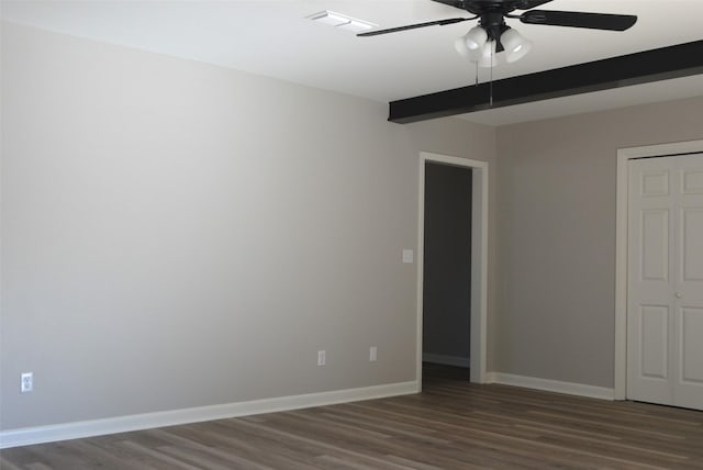 spare room featuring beamed ceiling, wood finished floors, visible vents, and baseboards