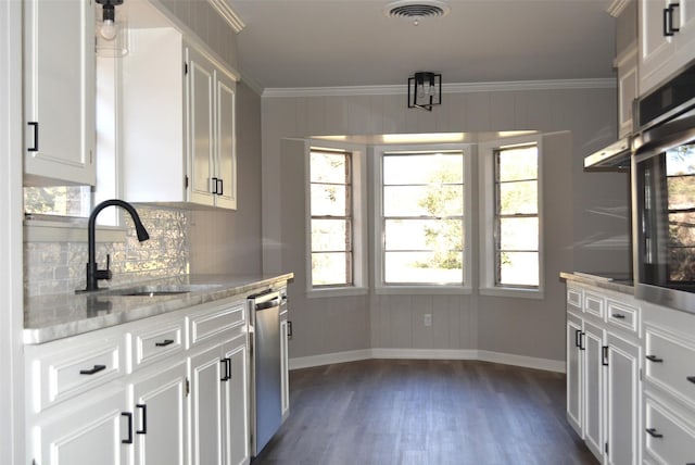 kitchen with crown molding, visible vents, stainless steel dishwasher, dark wood-type flooring, and a sink