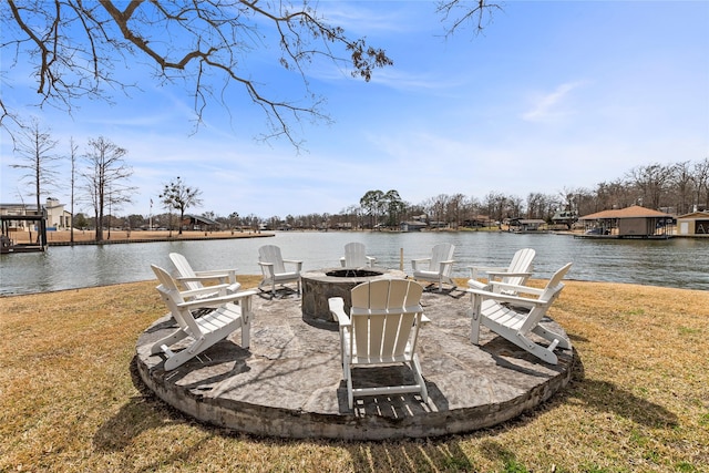 dock area with a water view, a patio area, an outdoor fire pit, and a lawn