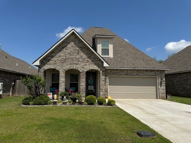 view of front of home with a shingled roof, driveway, brick siding, a front yard, and a garage
