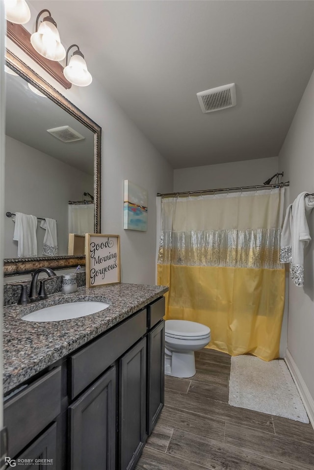 full bath featuring visible vents, toilet, a shower with shower curtain, wood finished floors, and vanity