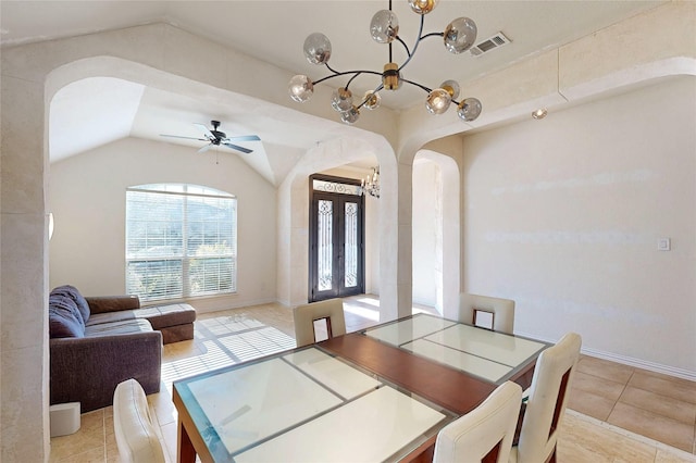 dining space with arched walkways, light tile patterned floors, visible vents, vaulted ceiling, and ceiling fan with notable chandelier