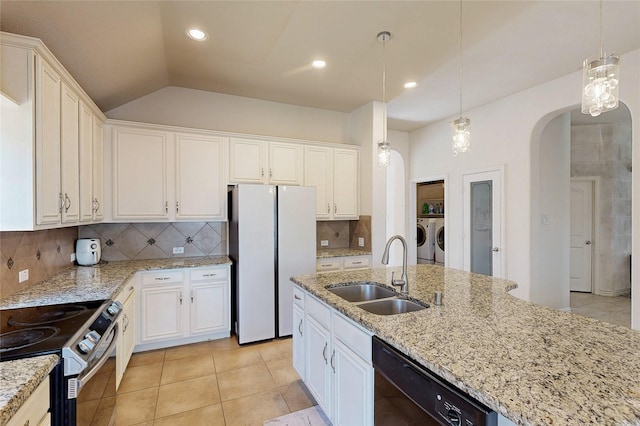 kitchen with black dishwasher, stainless steel electric range oven, washing machine and dryer, freestanding refrigerator, and a sink