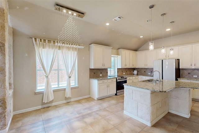 kitchen featuring tasteful backsplash, visible vents, freestanding refrigerator, stainless steel electric stove, and white cabinetry