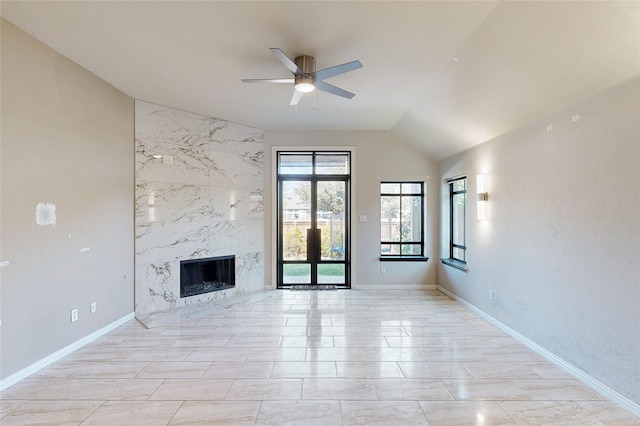 unfurnished living room featuring ceiling fan, baseboards, vaulted ceiling, and a high end fireplace