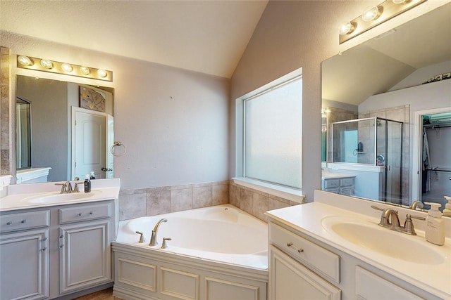 full bathroom featuring lofted ceiling, a stall shower, a sink, and a bath