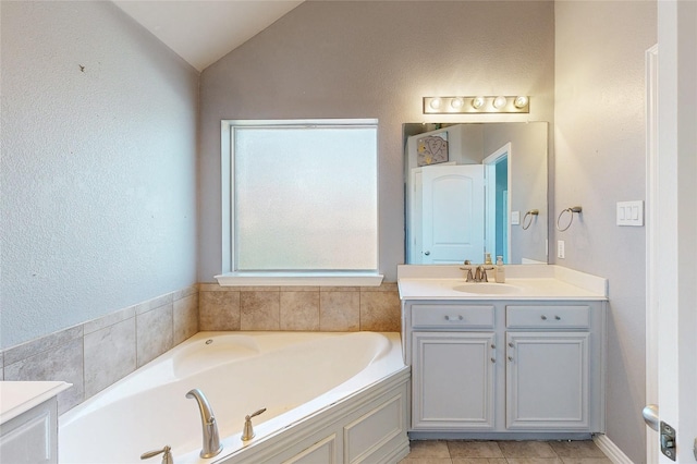 full bathroom featuring lofted ceiling, tile patterned floors, vanity, and a bath