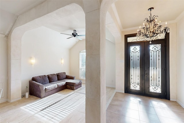 foyer with ornamental molding, french doors, light tile patterned floors, and arched walkways