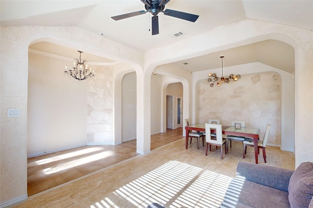 tiled dining room featuring visible vents, vaulted ceiling, arched walkways, and ceiling fan with notable chandelier