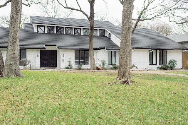 view of front of home featuring a front lawn and brick siding