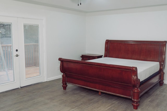 bedroom with french doors, wood finished floors, and baseboards