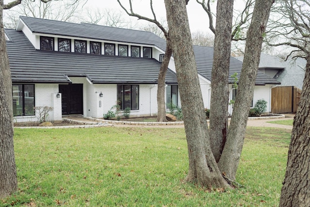 view of front of house with brick siding and a front lawn