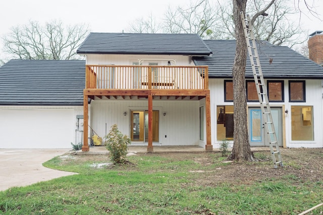 rear view of house featuring a garage, driveway, french doors, and a chimney