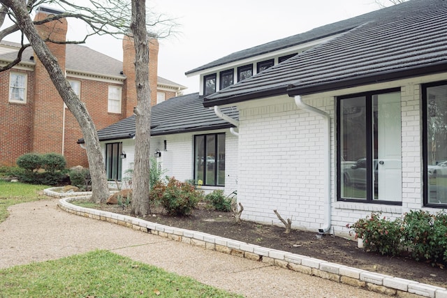 view of side of home with brick siding