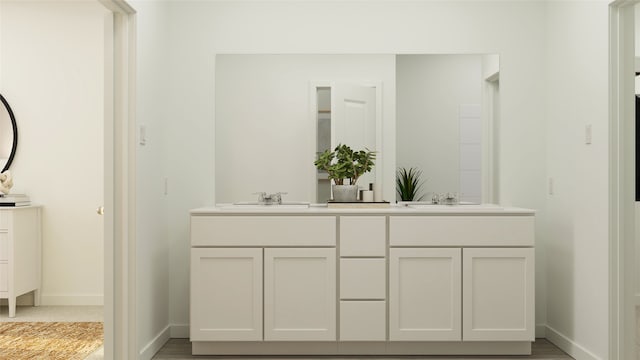 bathroom featuring double vanity, baseboards, and a sink