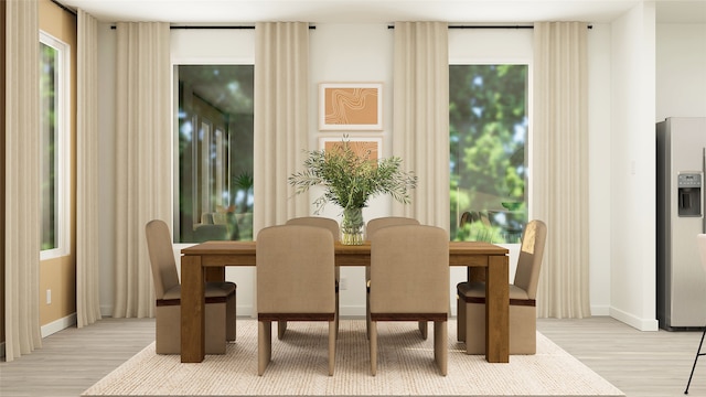 dining area featuring light wood-type flooring and baseboards