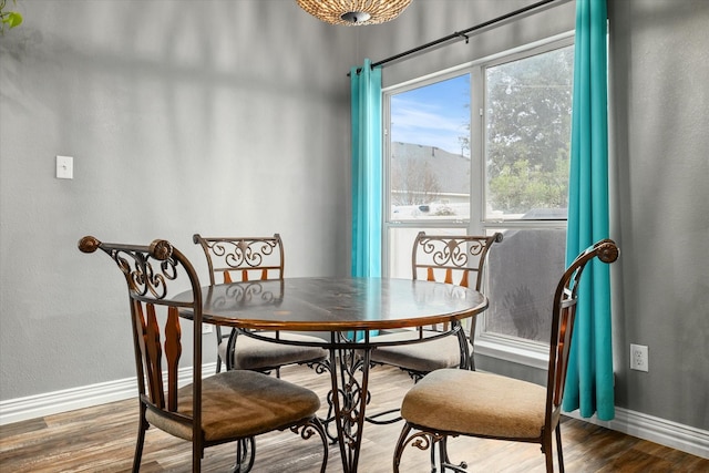 dining space featuring wood finished floors and baseboards