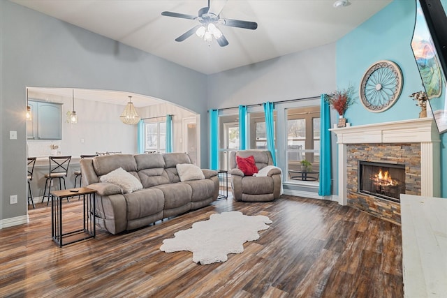 living area with a ceiling fan, a fireplace, plenty of natural light, and wood finished floors