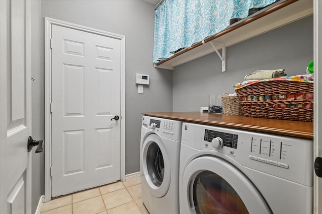 clothes washing area featuring washer and dryer, laundry area, and light tile patterned floors