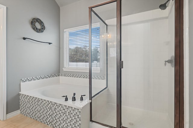 bathroom featuring tile patterned flooring, a garden tub, and a shower stall