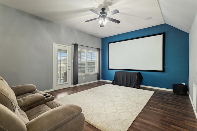 home theater with lofted ceiling, ceiling fan, dark wood-style flooring, and baseboards