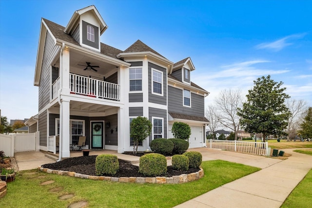 view of front of house with ceiling fan, fence, a balcony, and a garage