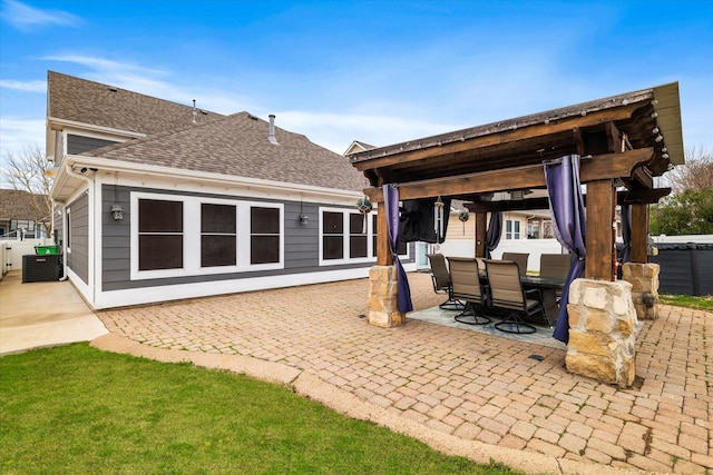 back of property featuring a patio, central air condition unit, a shingled roof, fence, and a gazebo