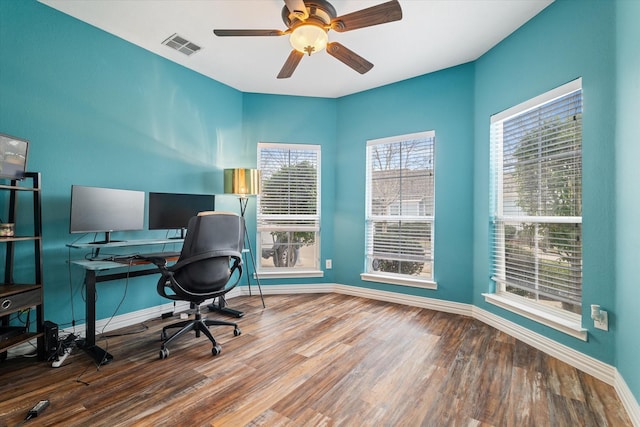 unfurnished office with a ceiling fan, baseboards, visible vents, and wood finished floors