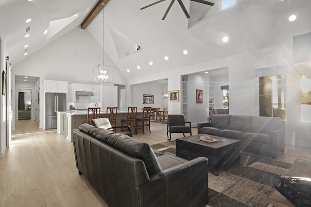 living room featuring beam ceiling, high vaulted ceiling, visible vents, light wood-style floors, and a chandelier