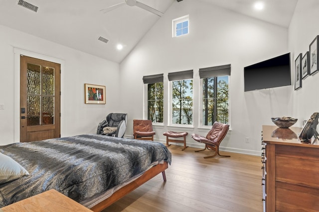 bedroom featuring high vaulted ceiling, wood finished floors, visible vents, and baseboards