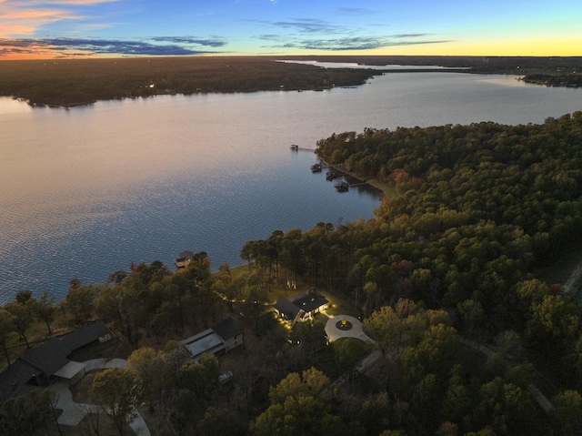 aerial view at dusk featuring a water view