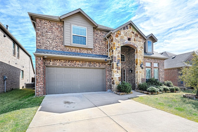 view of front facade featuring central AC unit, a garage, stone siding, driveway, and a front yard