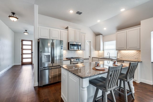 kitchen with white cabinetry, a kitchen island, visible vents, and stainless steel appliances