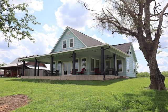 view of front of home with ceiling fan, a front lawn, a patio area, and a shingled roof