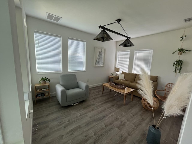 living area featuring a wealth of natural light, wood finished floors, visible vents, and baseboards