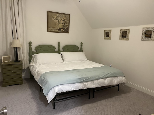 bedroom featuring lofted ceiling, baseboards, and carpet flooring