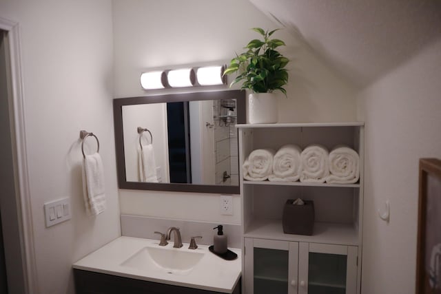 bathroom with lofted ceiling and vanity