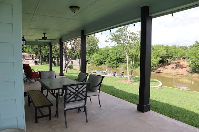 view of patio featuring outdoor dining space, a water view, and a ceiling fan