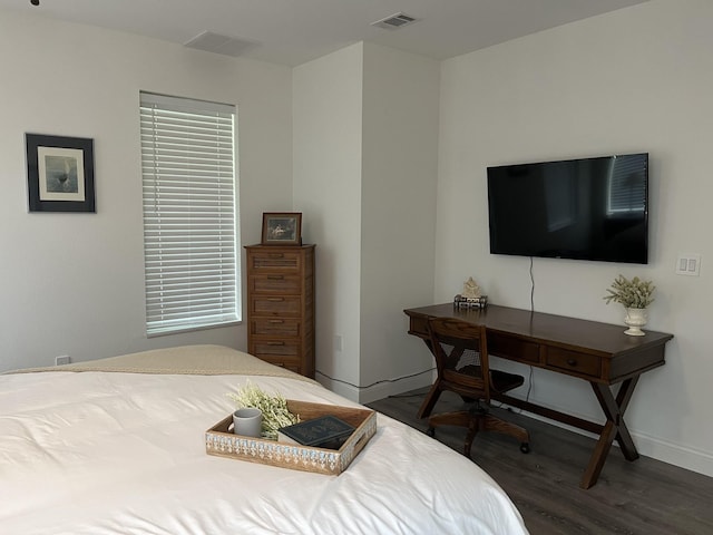 bedroom featuring visible vents, baseboards, and wood finished floors