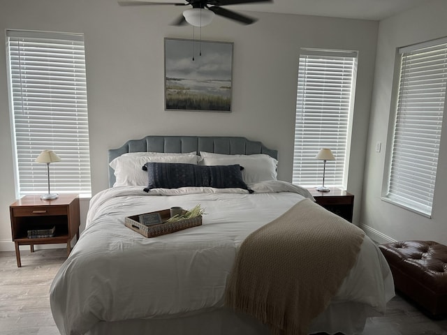 bedroom with ceiling fan, baseboards, and wood finished floors