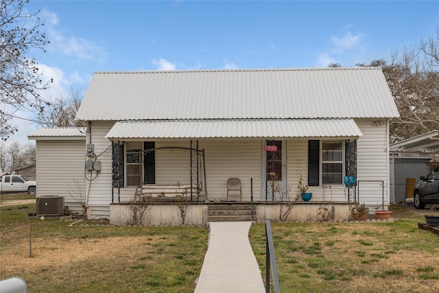 view of front of house featuring a porch, a front yard, metal roof, and central air condition unit