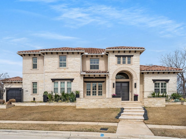 mediterranean / spanish home with stone siding and a tile roof