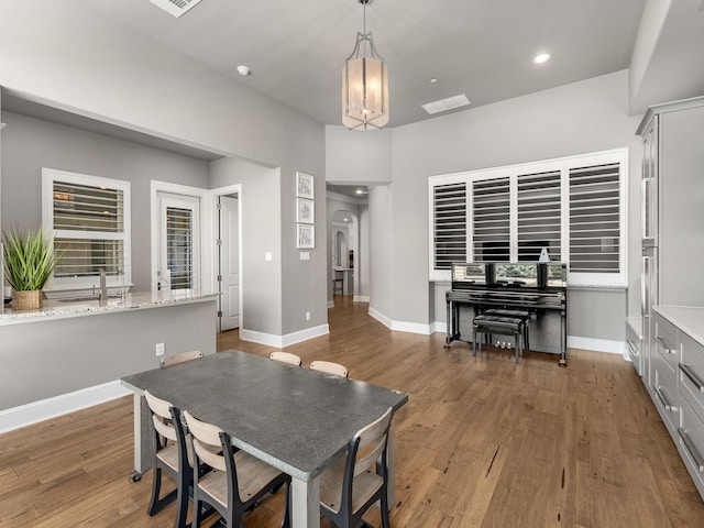 dining space with recessed lighting, wood finished floors, baseboards, and a chandelier