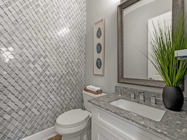 bathroom with vanity, toilet, and a shower