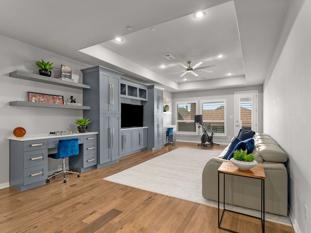 living room with visible vents, a ceiling fan, a tray ceiling, recessed lighting, and light wood finished floors