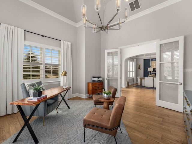 office featuring visible vents, arched walkways, a notable chandelier, and wood finished floors