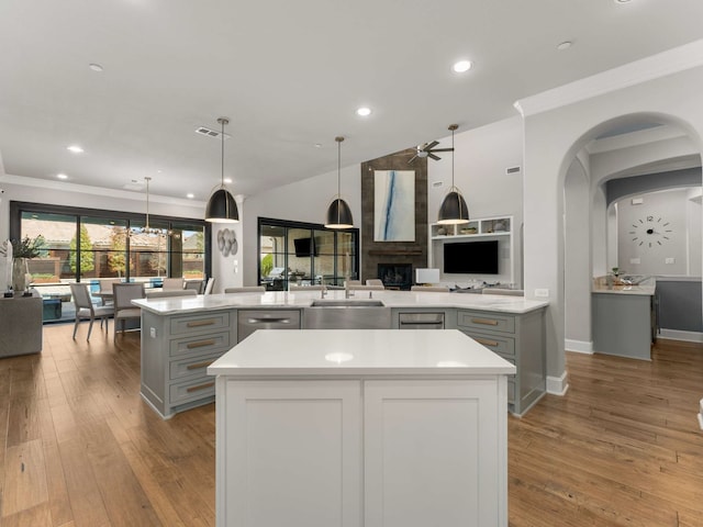 kitchen with a spacious island, ceiling fan, a sink, stainless steel dishwasher, and open floor plan