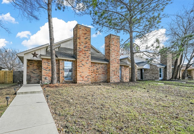 view of front of property featuring a chimney, roof with shingles, an attached garage, fence, and brick siding