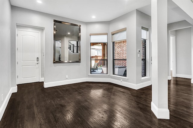 foyer entrance with baseboards and wood finished floors