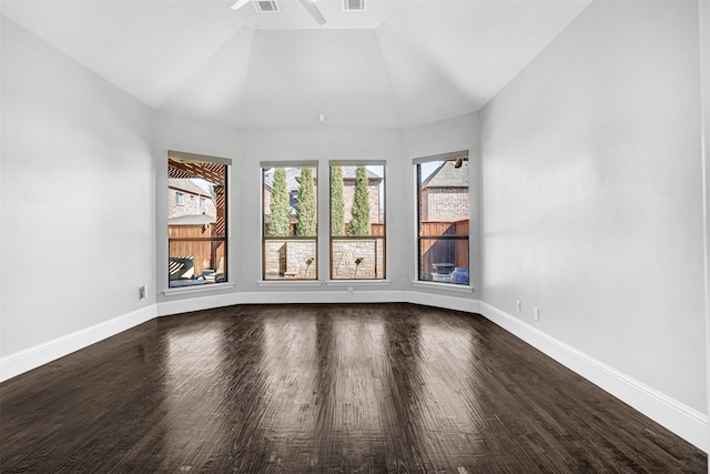 spare room featuring lofted ceiling, dark wood finished floors, visible vents, and baseboards